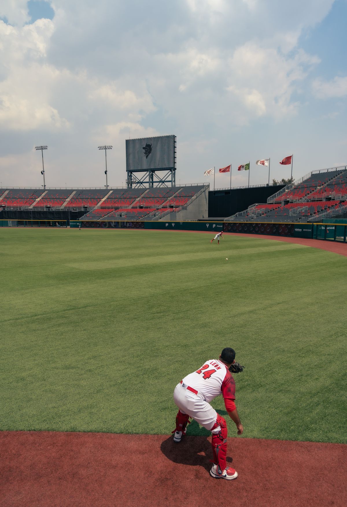 A baseball player on a field with stadium seating behind